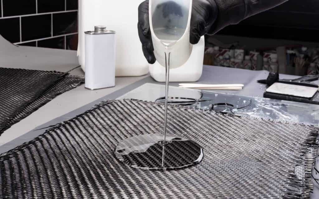 Rolls with various real woven carbon fiber enforcement raw material cloth composite material automotive and car tuning industry high tech background